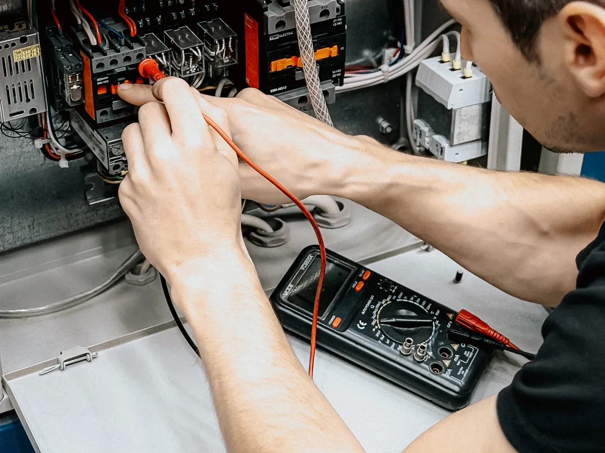 Electrician diagnosing an electrical panel with a multimeter